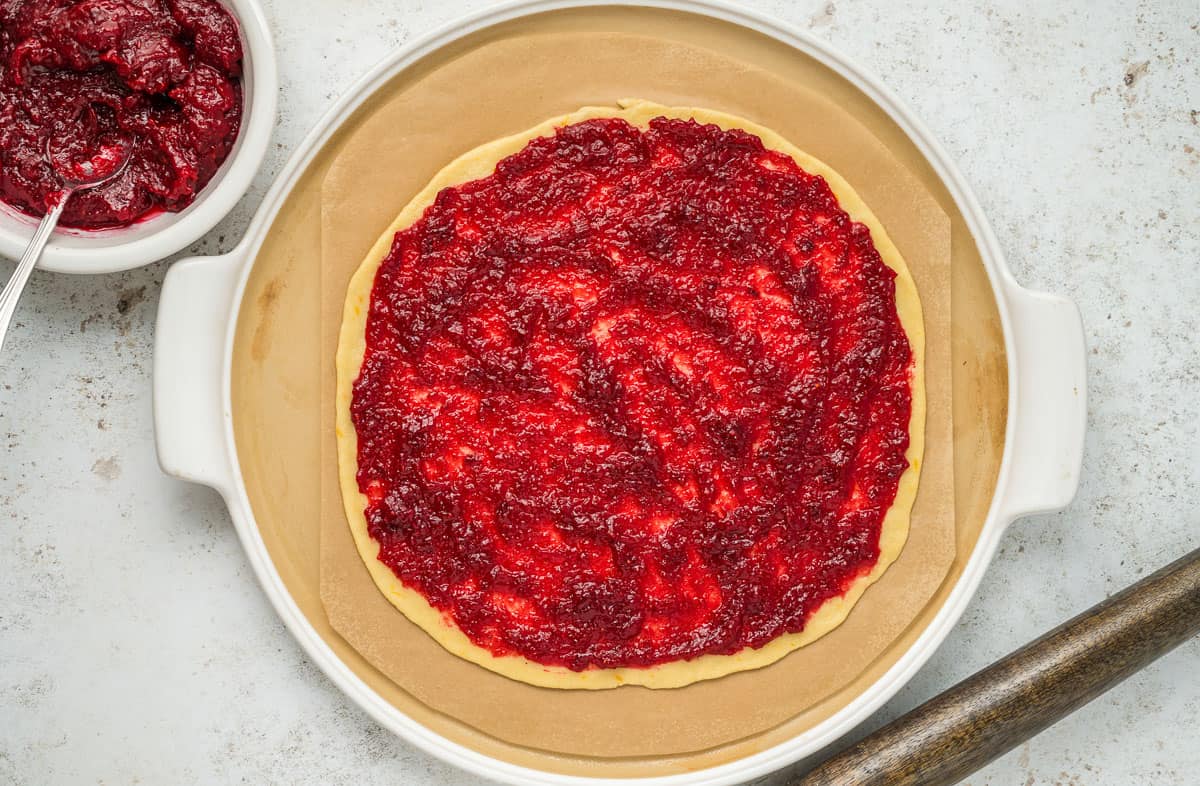 Cranberry sauce spread onto a circle of dough.
