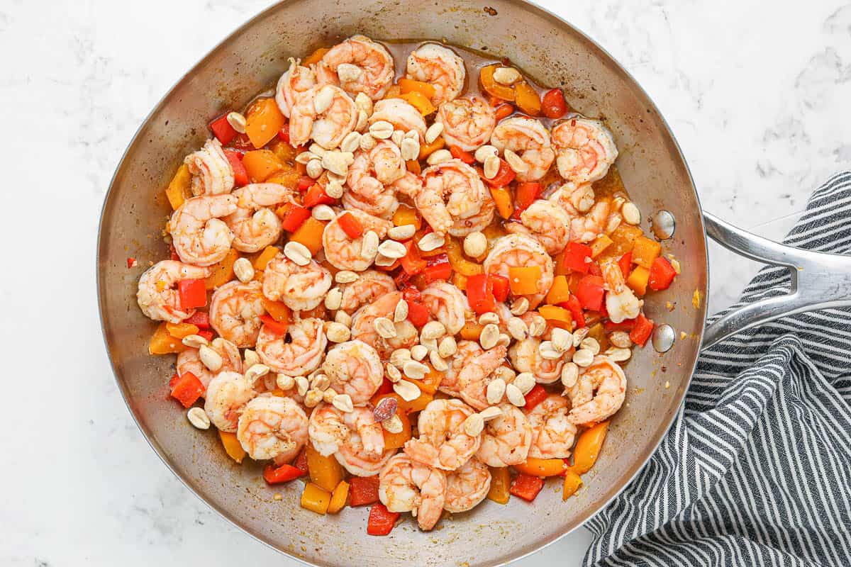 Peppers, shrimp and peanuts in a skillet.