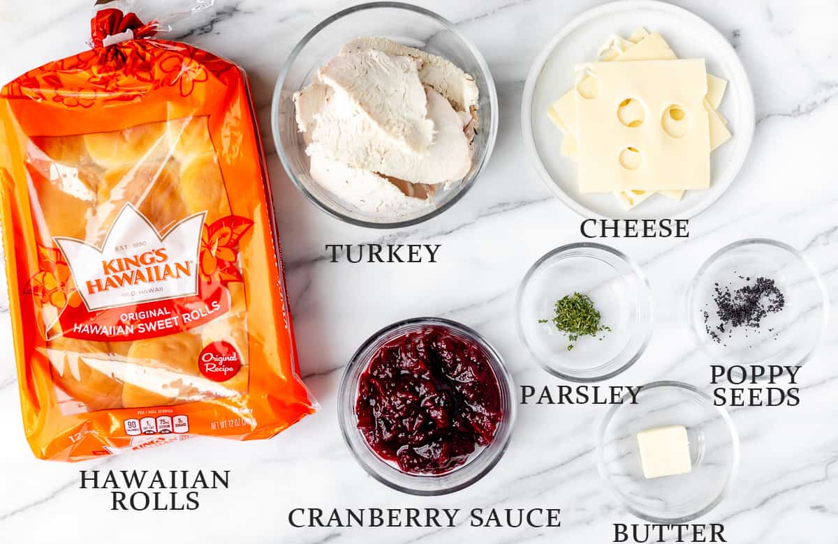 Ingredients needed to make turkey sliders on a marble background with text overlay.