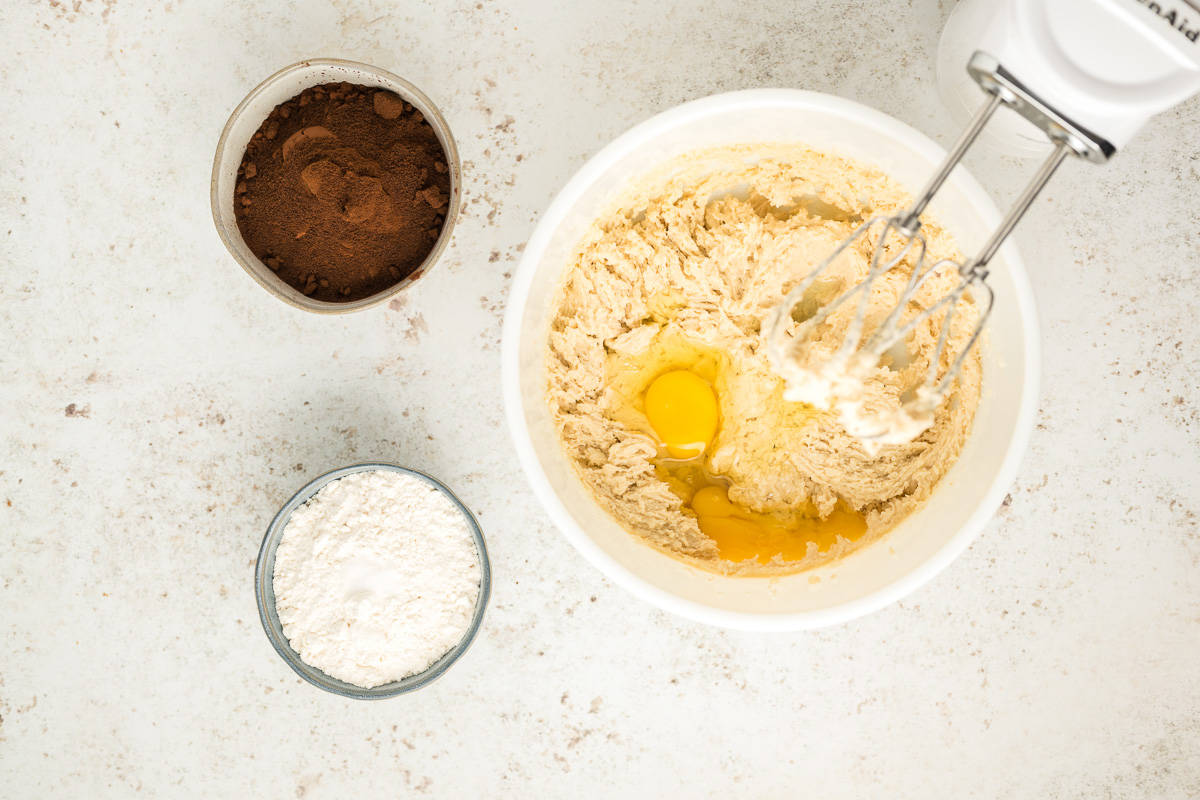 Butter, sugar, and eggs in the bowl of an electric mixer.