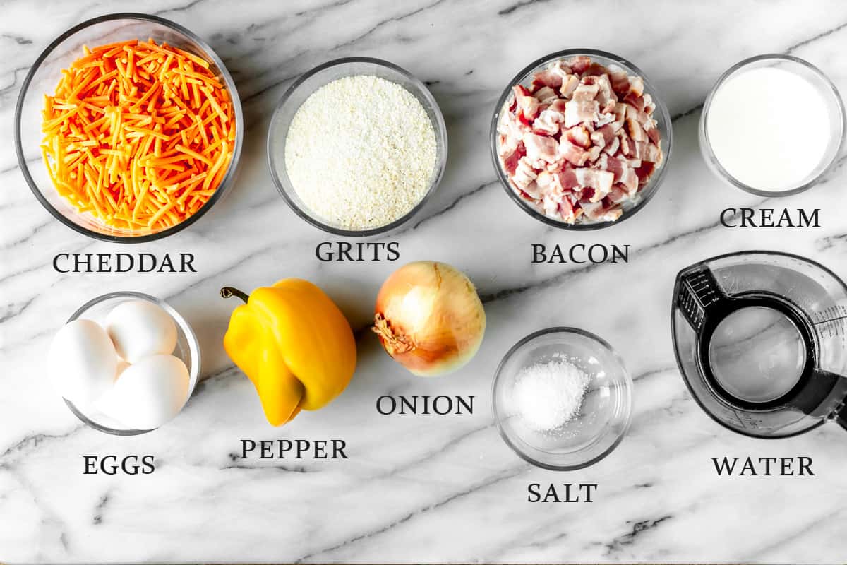 Ingredients needed to make a Grits Casserole on a marble surface with text overlay.