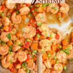 Close up of Kung Pao Shrimp in a skillet with a spoonful being lifted up with text overlay.