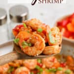 Kung Pao Shrimp in a skillet with a spoonful being lifted up with text overlay.