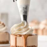 A mini Biscoff cheesecake with whipped cream being piped on with text overlay.