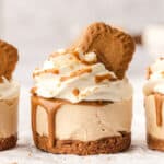 Close up of a single mini Biscoff cheesecake with 2 other cheesecakes partially showing on each side.