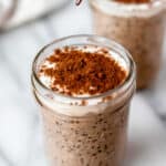 Two jars of tiramisu overnight oats topped with yogurt and cocoa powder with text overlay.
