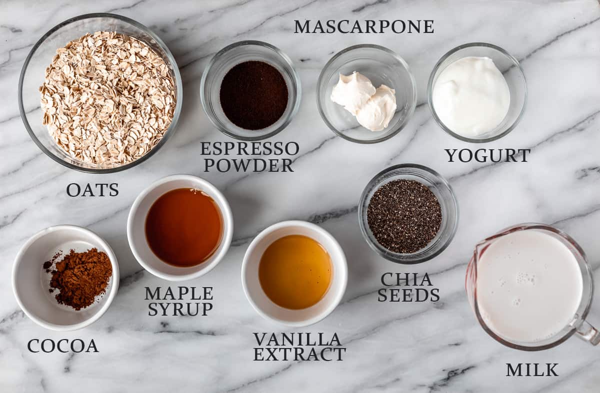Ingredients needed to make tiramisu overnight oats on a marble background with text overlay.