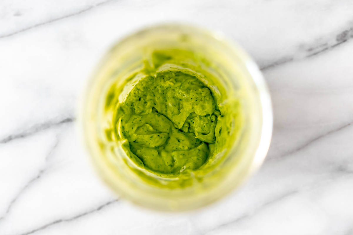 Cilantro Lime Avocado Dressing in the bottom of a blender cup.