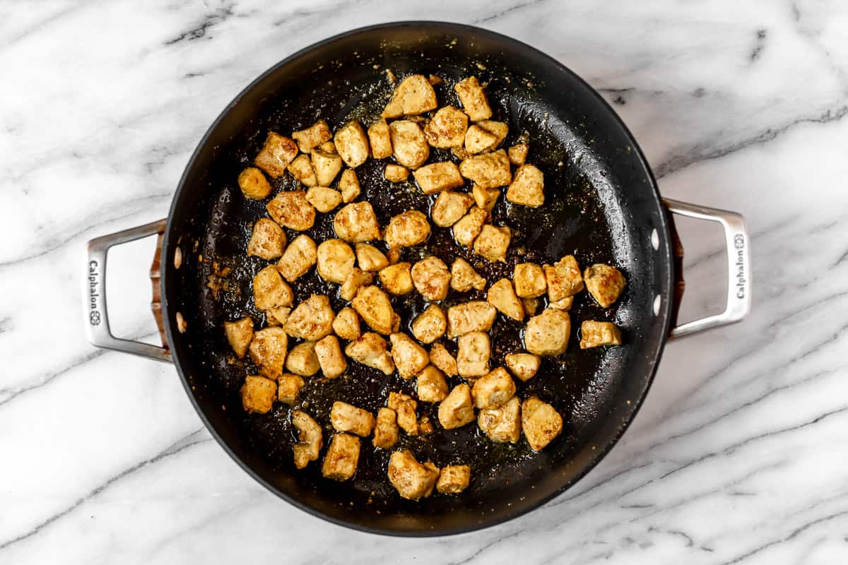 Cooked diced chicken in a black skillet.