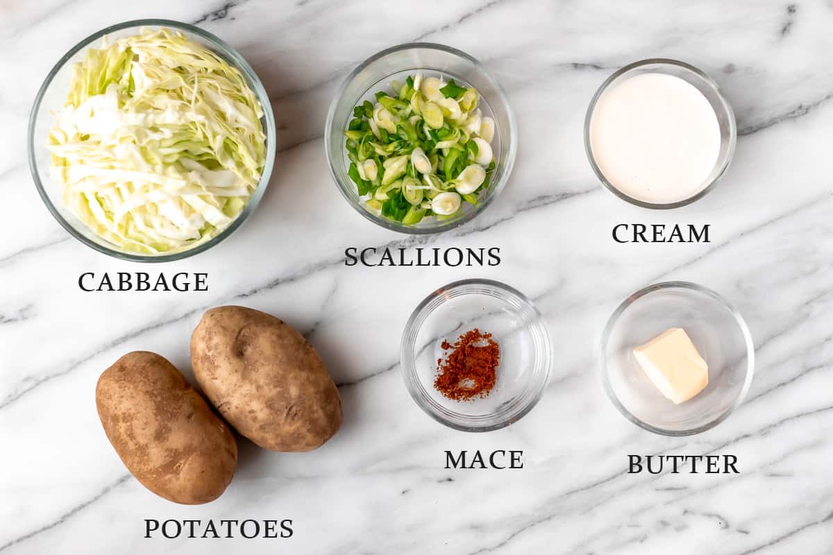Ingredients to make colcannon on a marble background with text overlay.