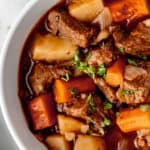 Overhead close up of a bowl of Guinness beef stew with text overlay.