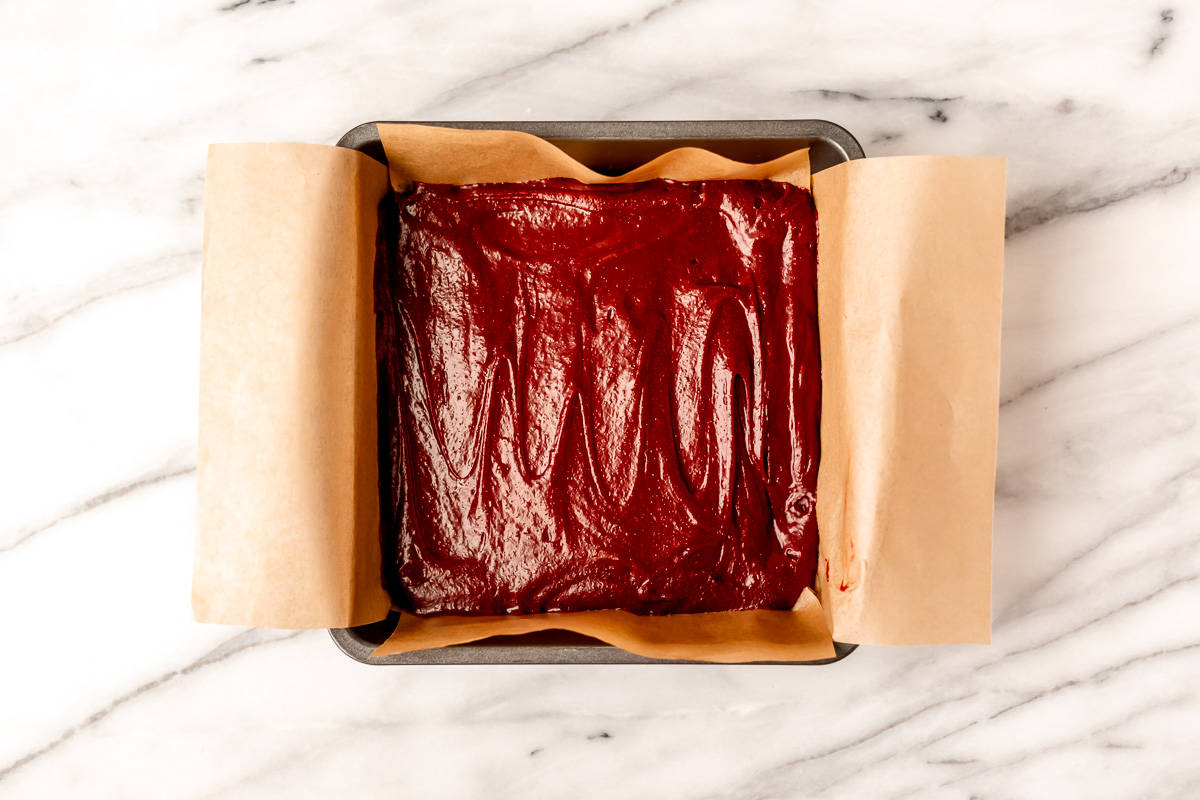 Red velvet brownie batter in an 8-inch square baking pan.