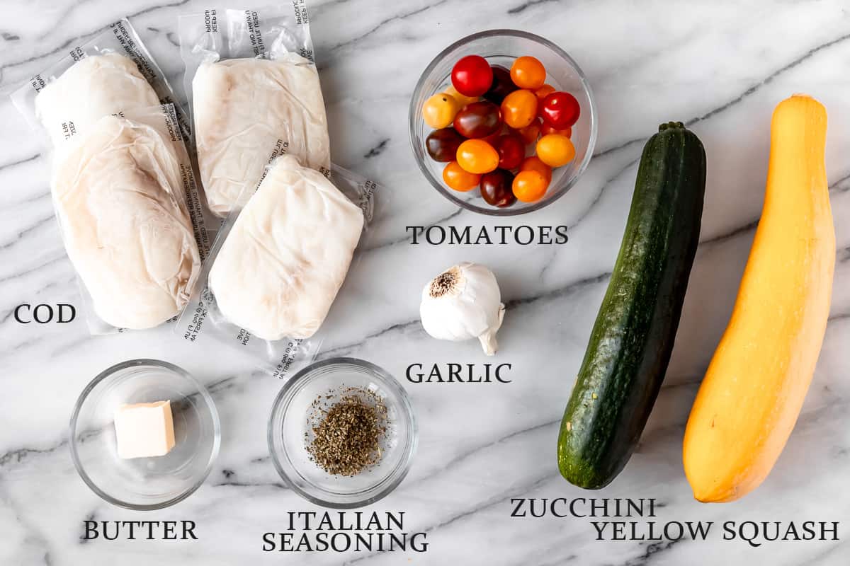 Ingredients needed to. make baked cod in foil on a marble background with text overlay.
