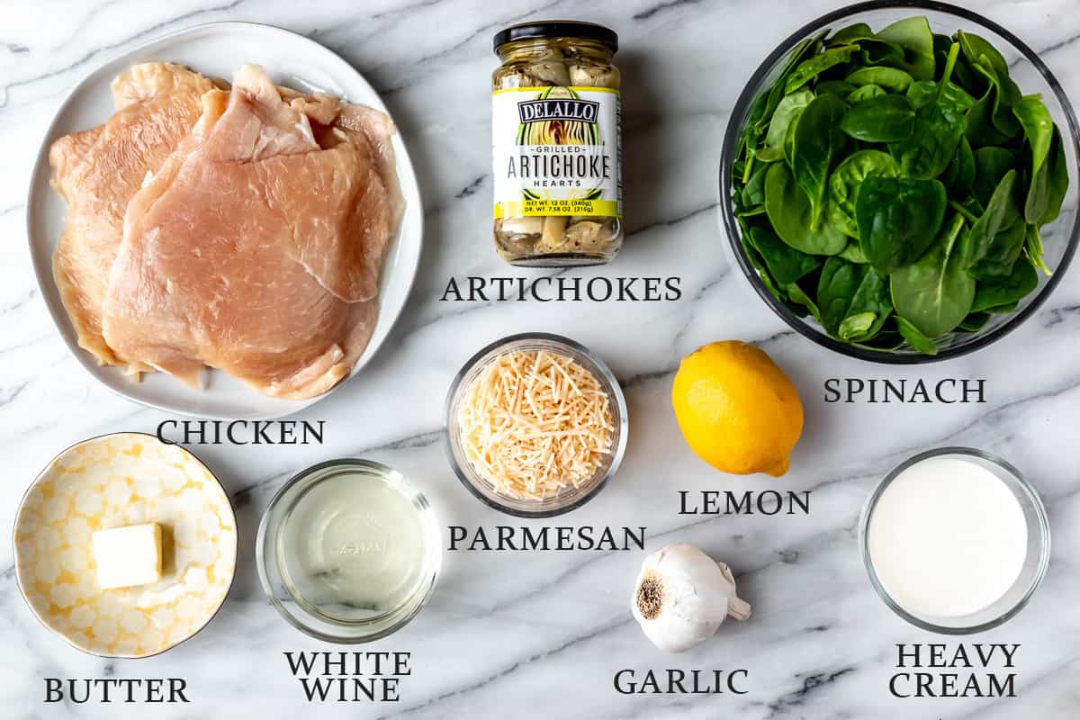 Ingredients needed to make spinach artichoke chicken on a marble background with text overlay.