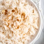 Close up of a white bowl of ginger rice with text overlay.