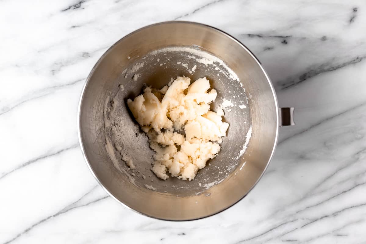 Butter and sugar creamed together in a silver mixing bowl.