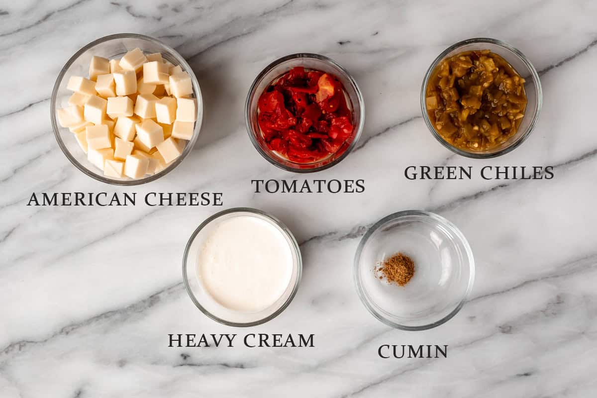 Ingredients needed to make queso on a marble background with text overlay.