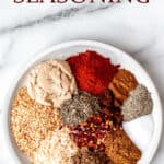 A plate of all the spices needed to make jerk seasoning on a white plate with text overlay.