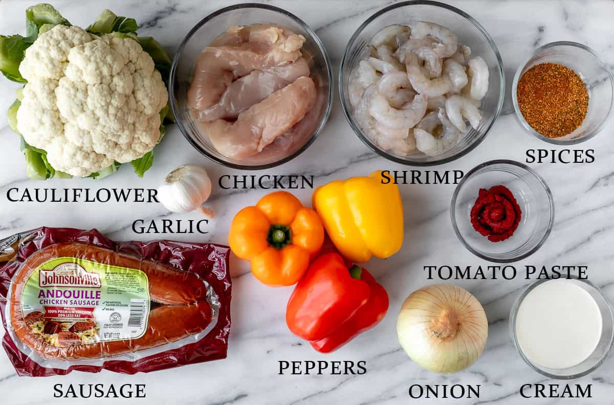 Ingredients needed to make keto jambalaya on a marble background with text overlay.