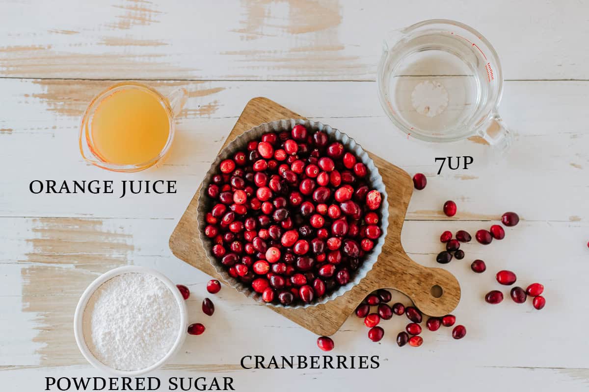 Ingredients needed to make candied cranberries on a light surface with text overlay.