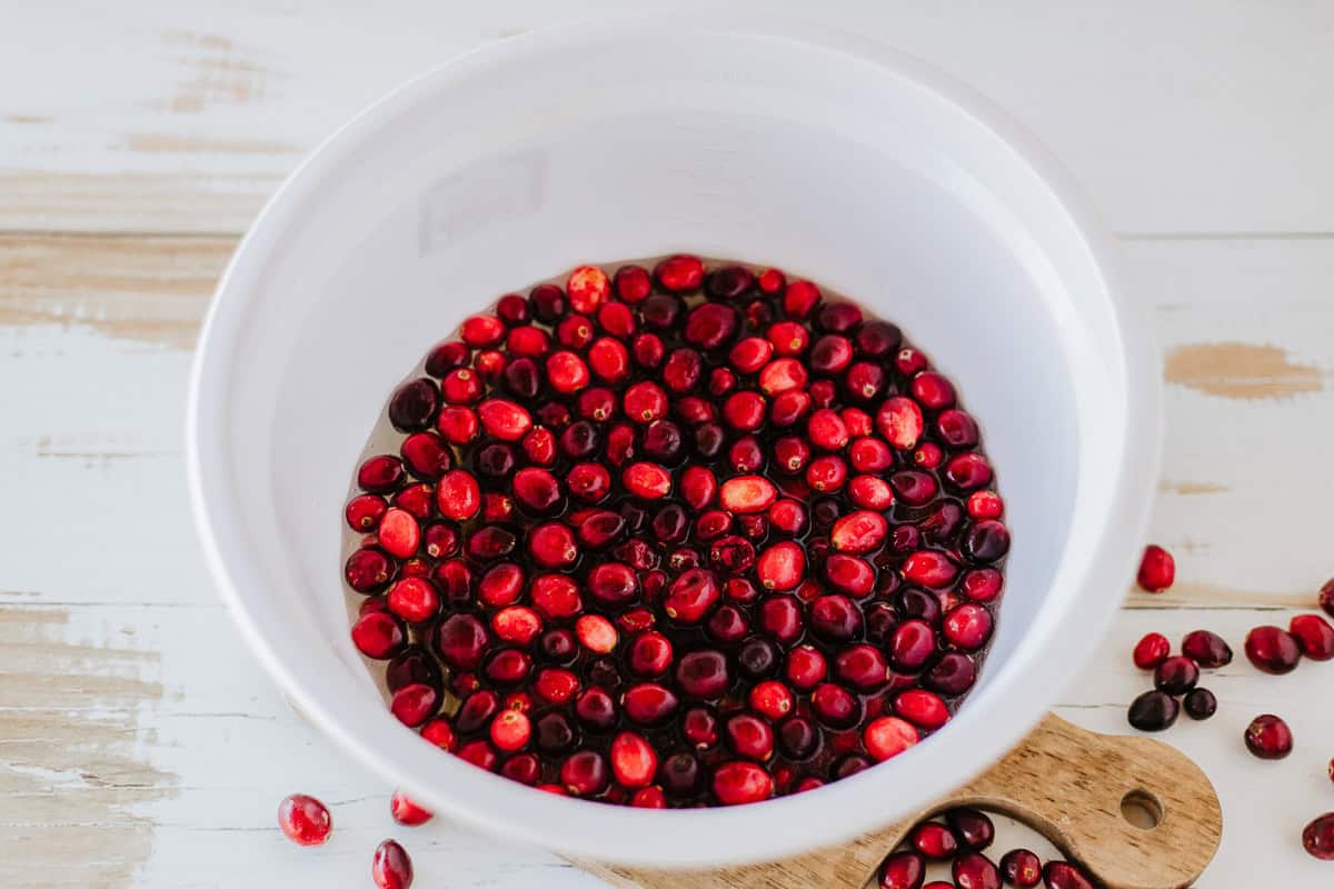 Cranberries soaking in a large white bowl.