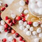 Overhead view of candied and plain cranberries on a wood board with text overlay.