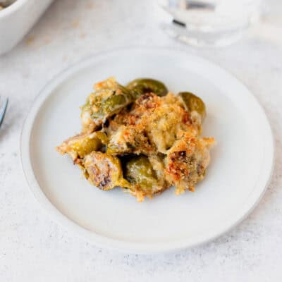 A small, white plate of brussels sprouts gratin.