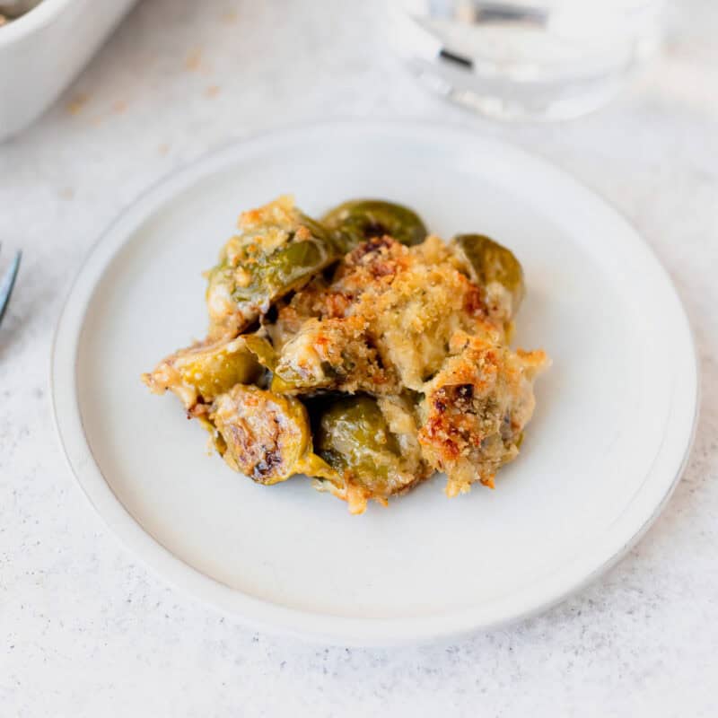 A small, white plate of brussels sprouts gratin.