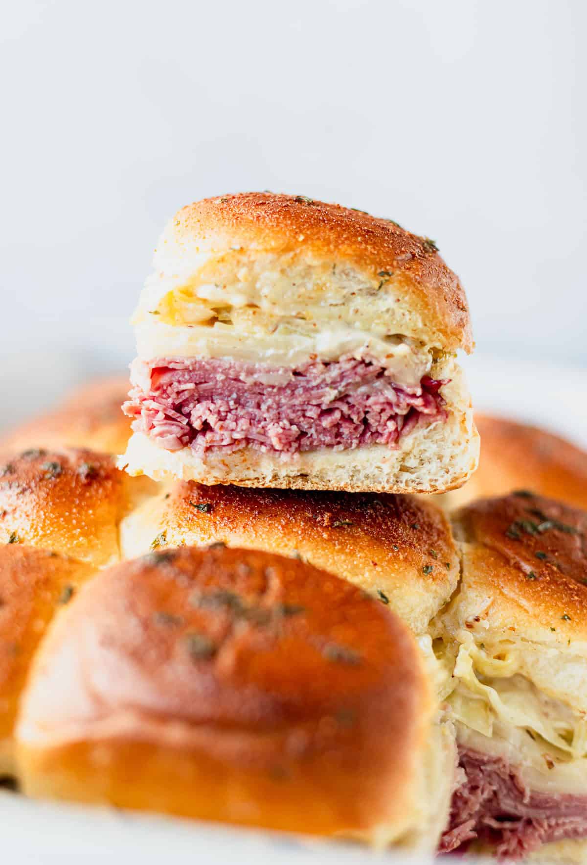 A corned beef slider sitting on top of more sliders.