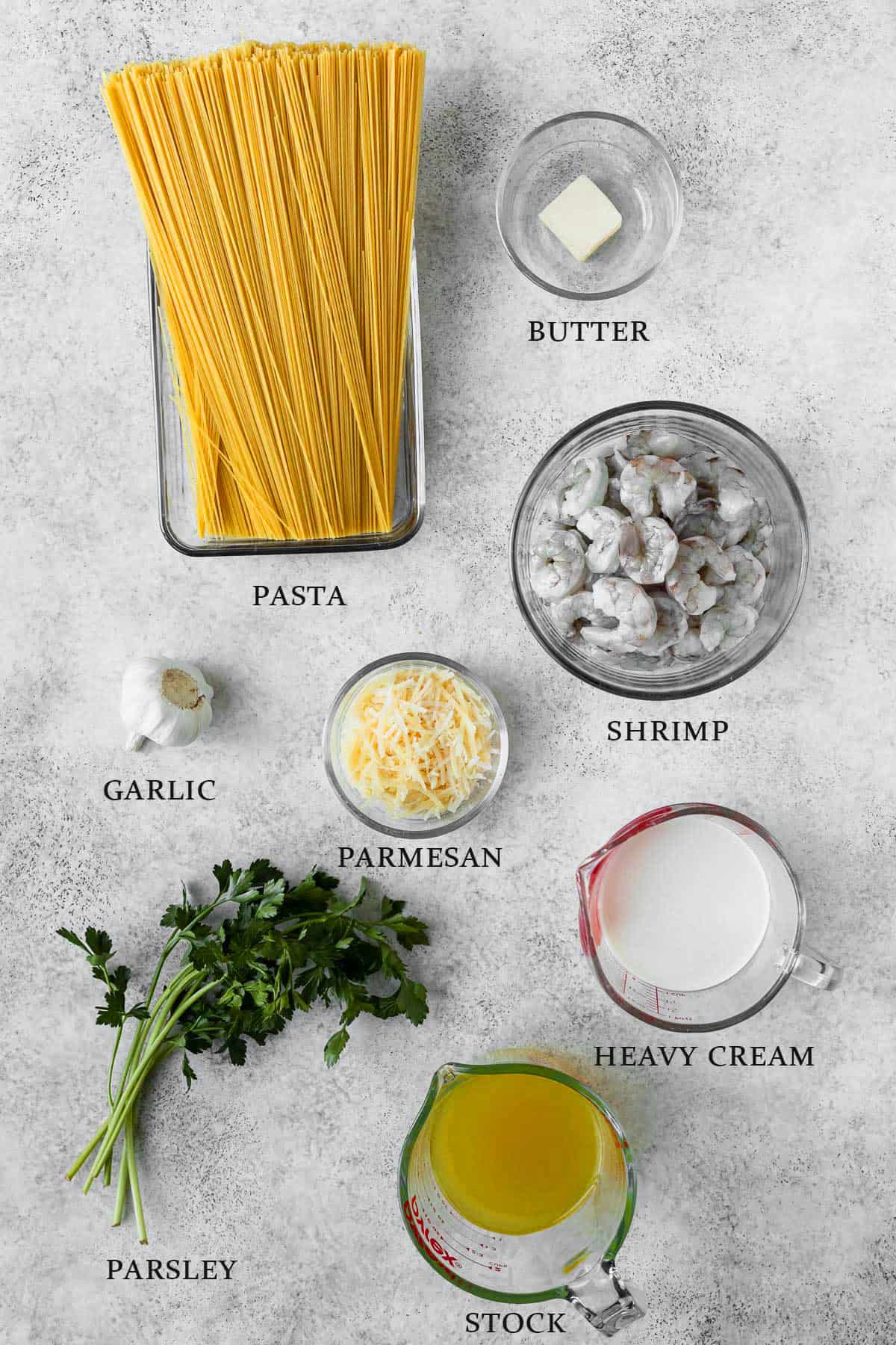 Ingredients needed to make shrimp parmesan pasta on a light background with text overlay.
