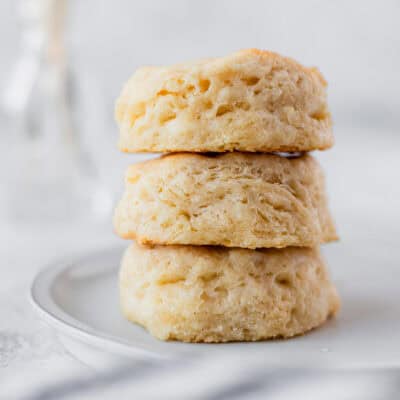A stack of three buttermilk biscuits on a white plate.