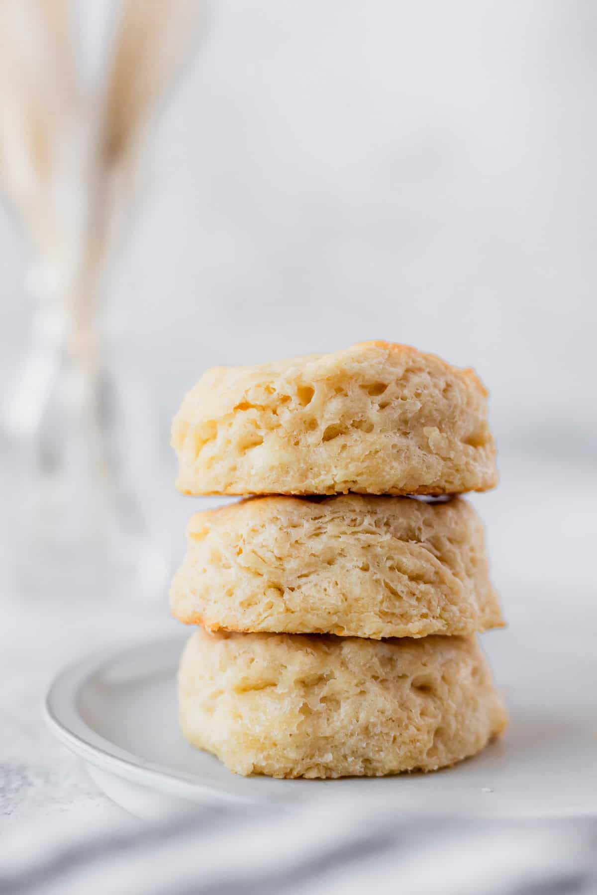 A stack of three buttermilk biscuits on a white plate.
