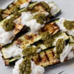 Grilled zucchini slices topped with burrata cheese and pesto.