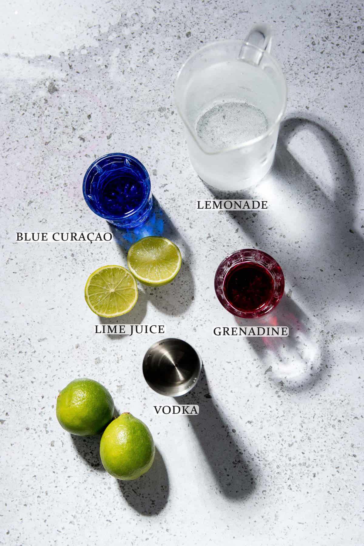 Ingredients needed to make a purple rain cocktail on a white surface with text overlay.