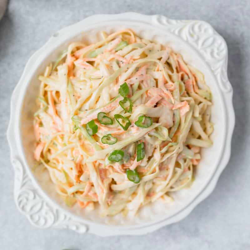 Overhead view of a white bowl filled with ranch coleslaw.
