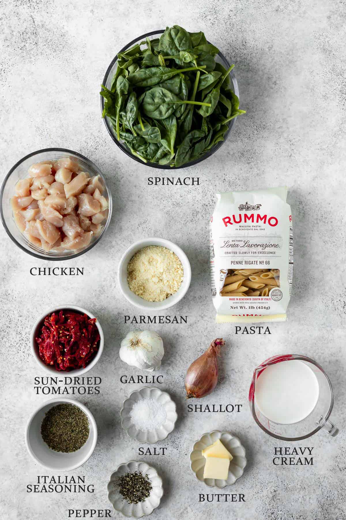 Ingredients needed to make Tuscan chicken pasta on a light background with text overlay.