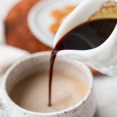 Gingerbread syrup being pour into a coffee mug.