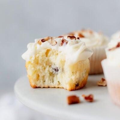 An Italian Cream Cupcake with a bite taken out of it.