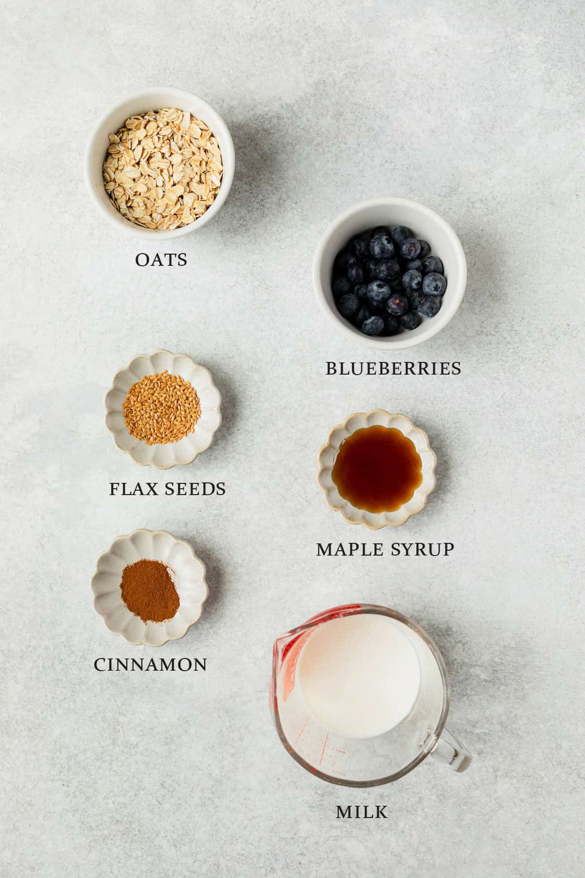 Ingredients needed to make blueberry overnight oats on a light colored background with text overlay.