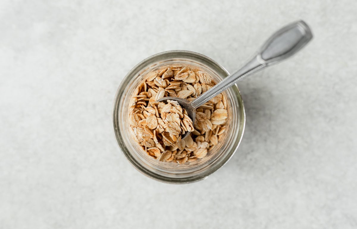Oats, flax seeds and cinnamon in a mason jar with a spoon.