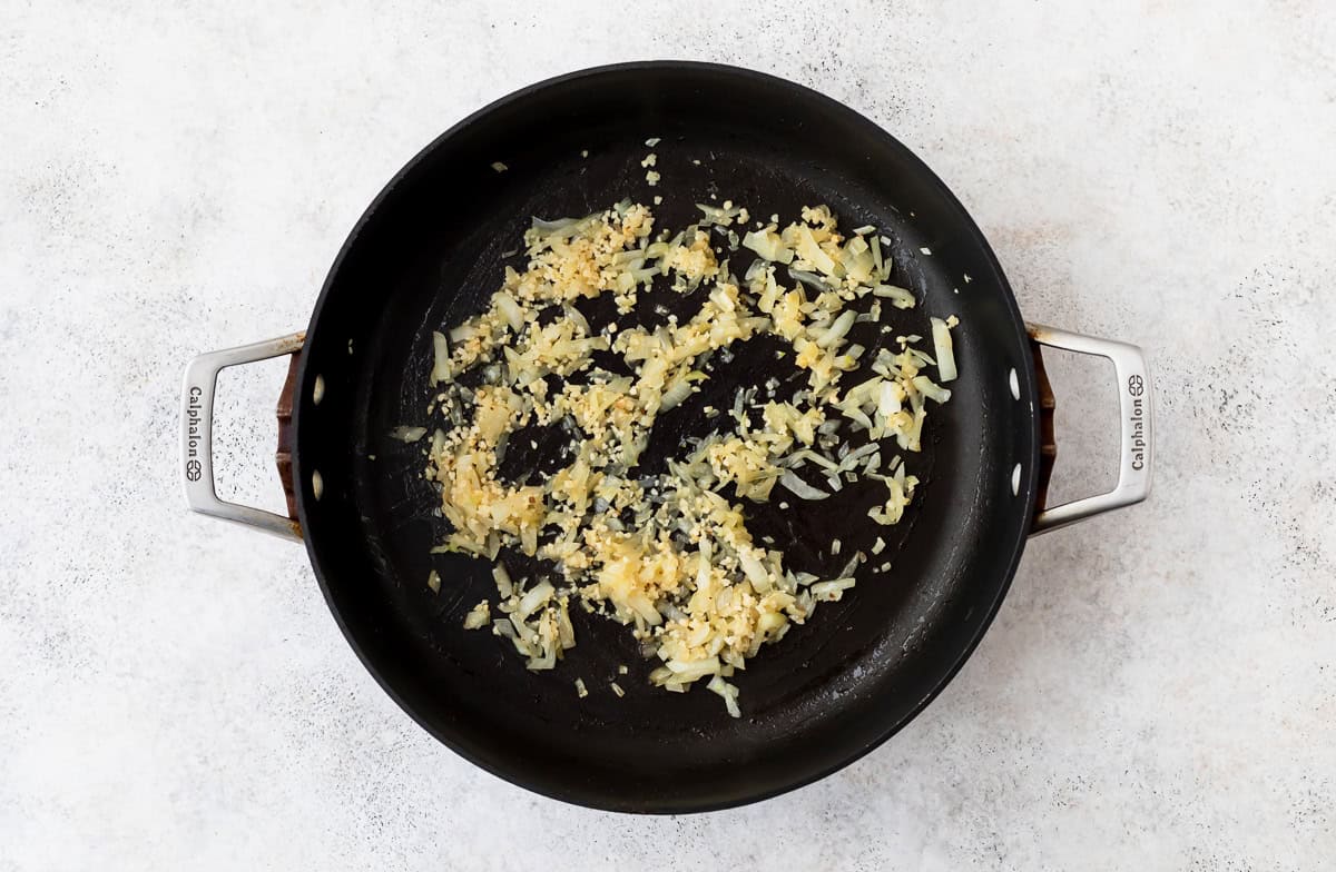 Diced onion and garlic in a large black skillet.