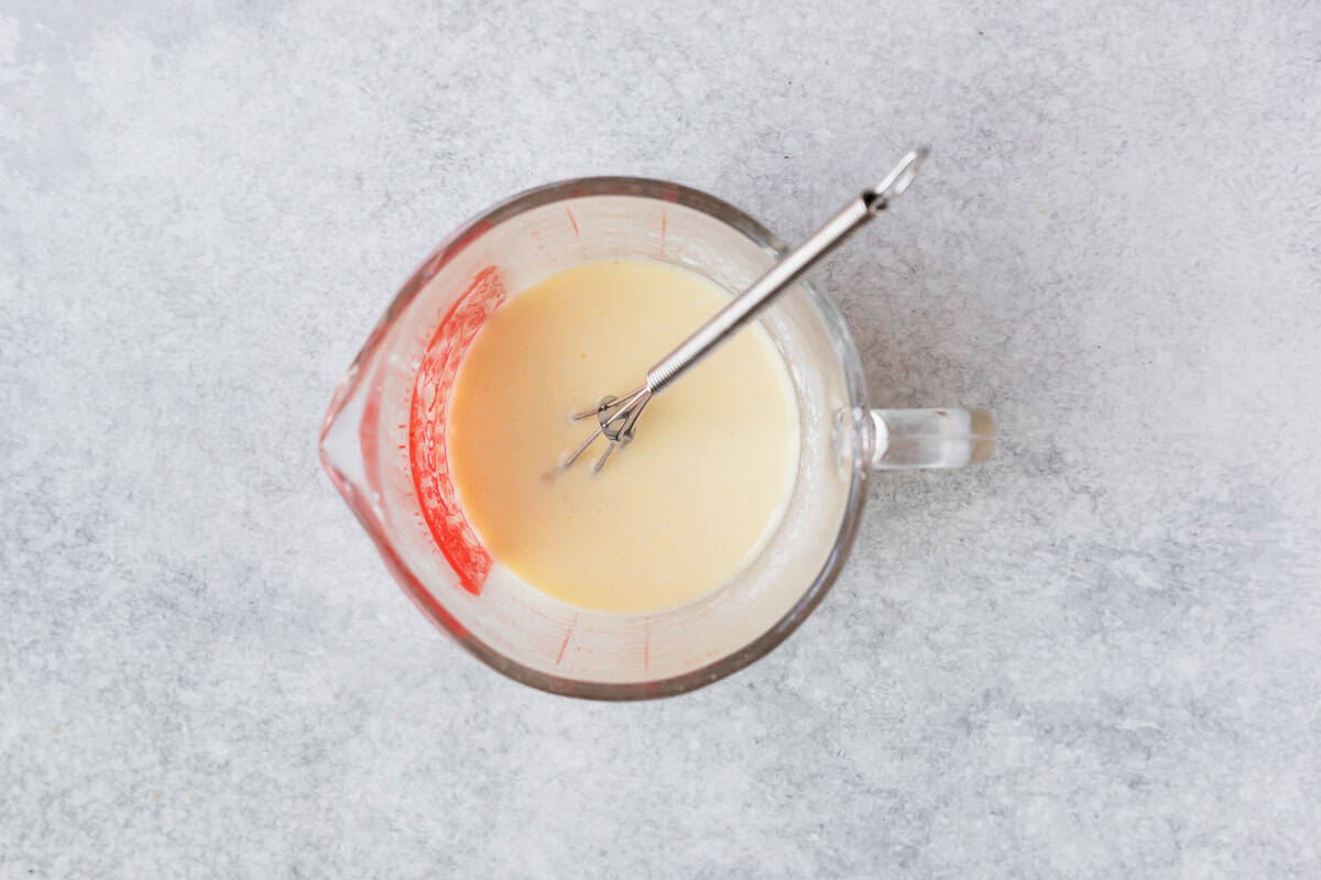 Buttermilk and egg whisked together in a glass measuring bottle.