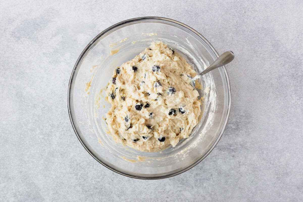 White chocolate chip blueberry scones dough in a glass bowl.